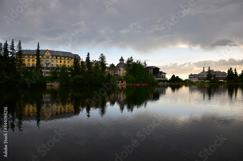 Strbske pleso, lake and small town, in the evening. Buildings and trees reflecting in the lake. High Tatras, Slovakia.