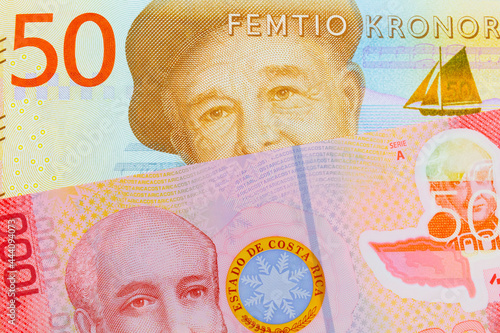 A macro image of a gray and orange fifty kronor note from Sweden paired up with a colorful red one thousand colones bank note from Costa Rica.  Shot close up in macro. photo