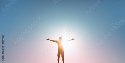 People happiness, hope, light , and power concept. Man with arms raised to the colorful sky  photo