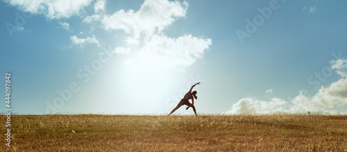 Canvas Print young female doing stretching exercises outdoors in a beautiful nature setting