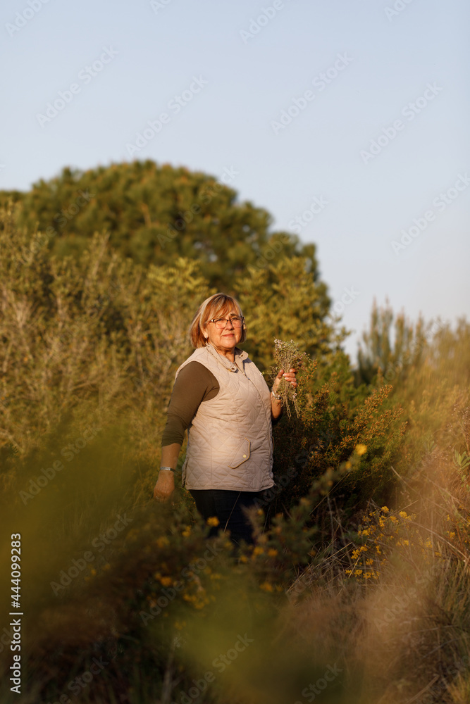 Mature woman wearing a bouquet of flowers in the forest Mature woman wearing a bouquet of flowers in the forest