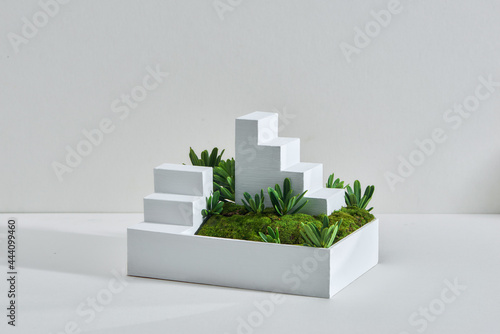 The miniature landscape of a park with trees a small stair and grass. photo