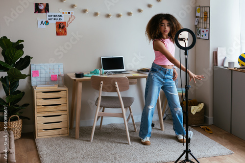 Hispanic girl dancing and recording video for vlog photo