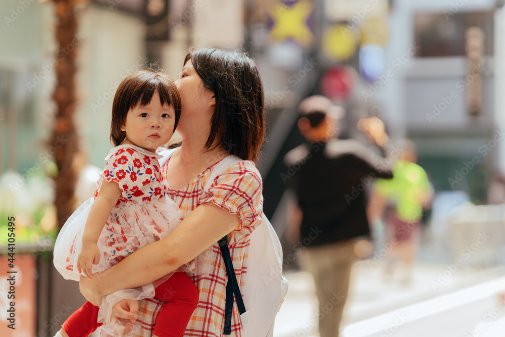 Mother hugging little girl on the street