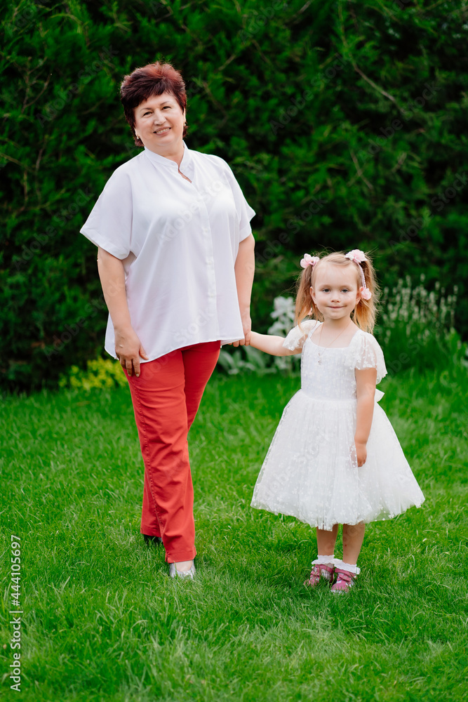 old mother with a little daughter in the garden. late pregnancy and childbirth. old mother with a little daughter in the garden. late pregnancy and childbirth.