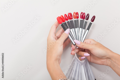 Photo Female hands holding red nail polish palette colors, copy space