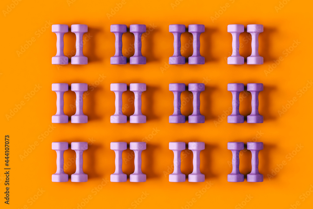 top down view of Purple dumbbells on orange background top down view of Purple dumbbells on orange background