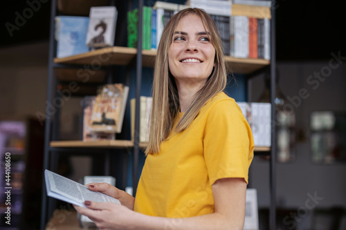 Student Taking A Book From The Shelf 