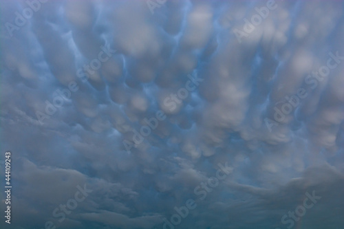 Breathtaking mammatus clouds above roofs in sunset July 08, 2021