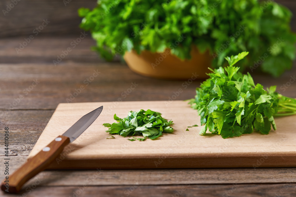 Fresh chopped green parsley leaves on a cutting board, selective focus. Fresh chopped green parsley leaves on a cutting board, selective focus.