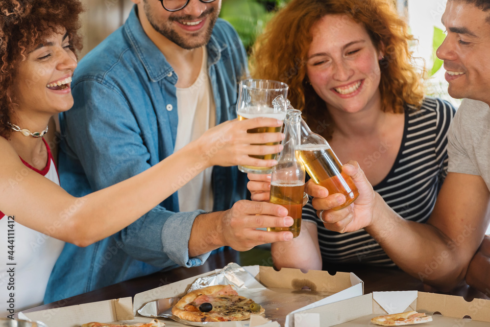 Multiethnic Group Of Young People Having Fun, Eating Pizza And Drinking Beer Together. Multiethnic Group Of Young People Having Fun, Eating Pizza And Drinking Beer Together.
