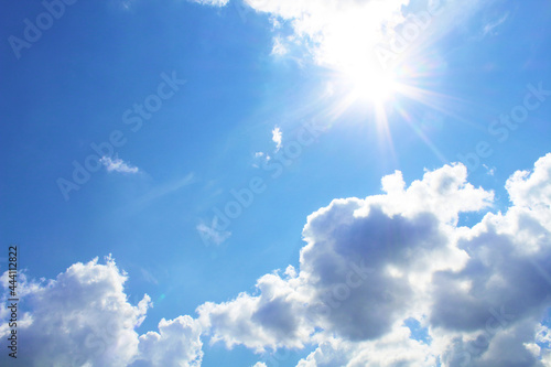 The bright scorching sun and cumulus clouds. Background. Scenery.