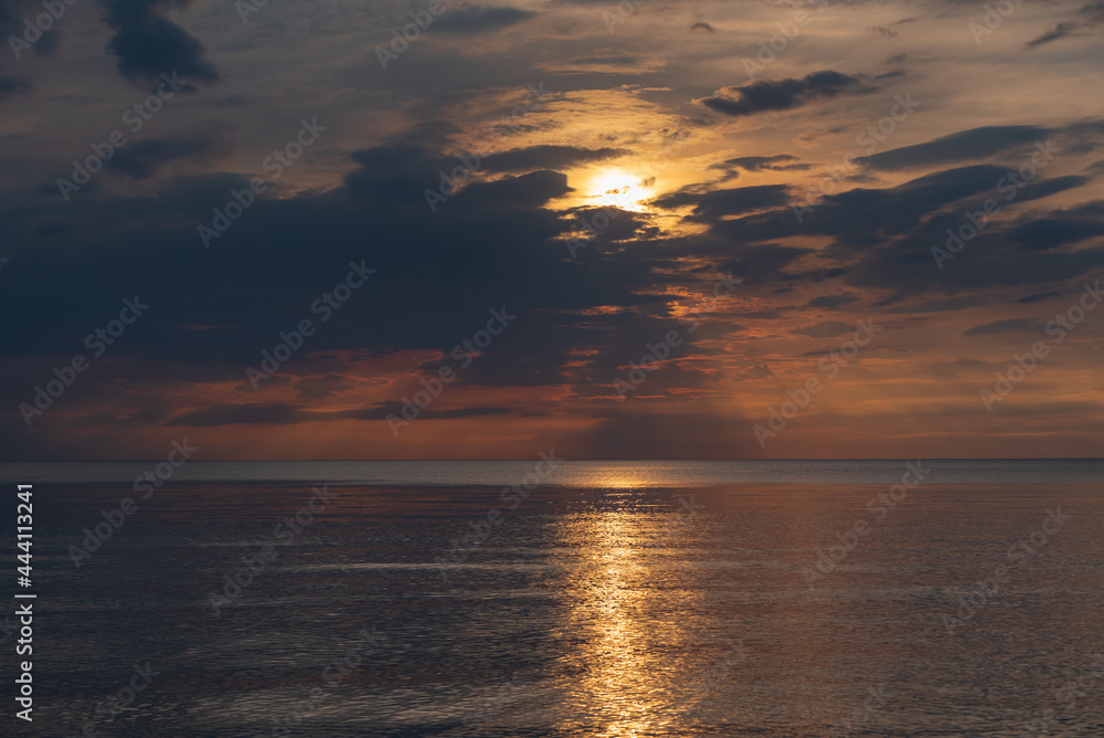 sunset in the sea with clouds and calm water sunset in the sea with clouds and calm water