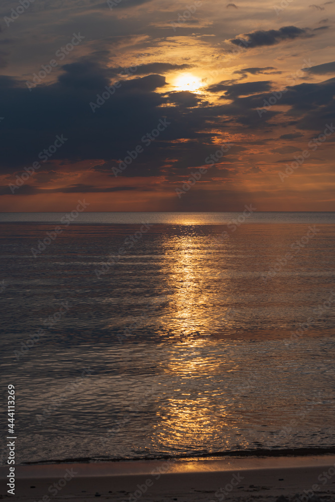 Fototapeta premium sunset in the sea with clouds and calm water