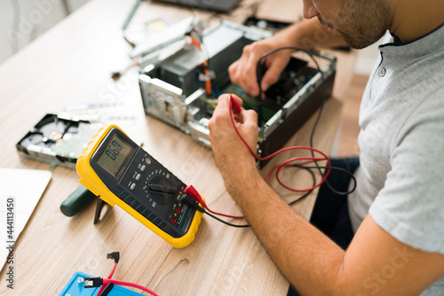 Professional engineer connecting a multimeter to a pc photo