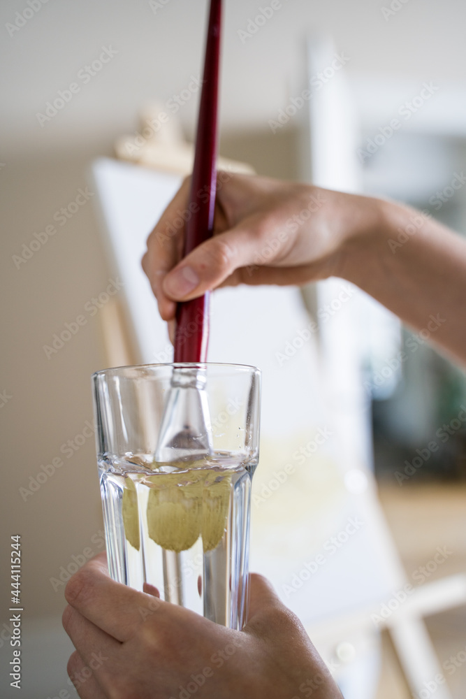 The artist moisturizes the brush in a glass of water. drawing. Hobbies and recreation The artist moisturizes the brush in a glass of water. drawing. Hobbies and recreation
