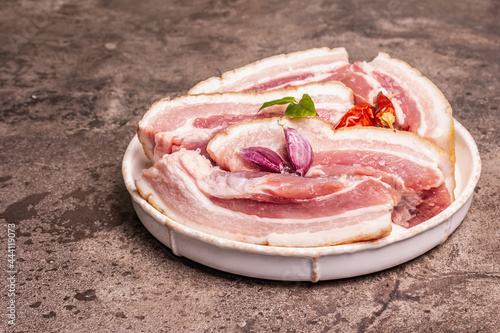 Raw pork belly with rind, peritoneum meat, spices and herbs photo