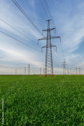 power lines run through green farmland with rich blue skies