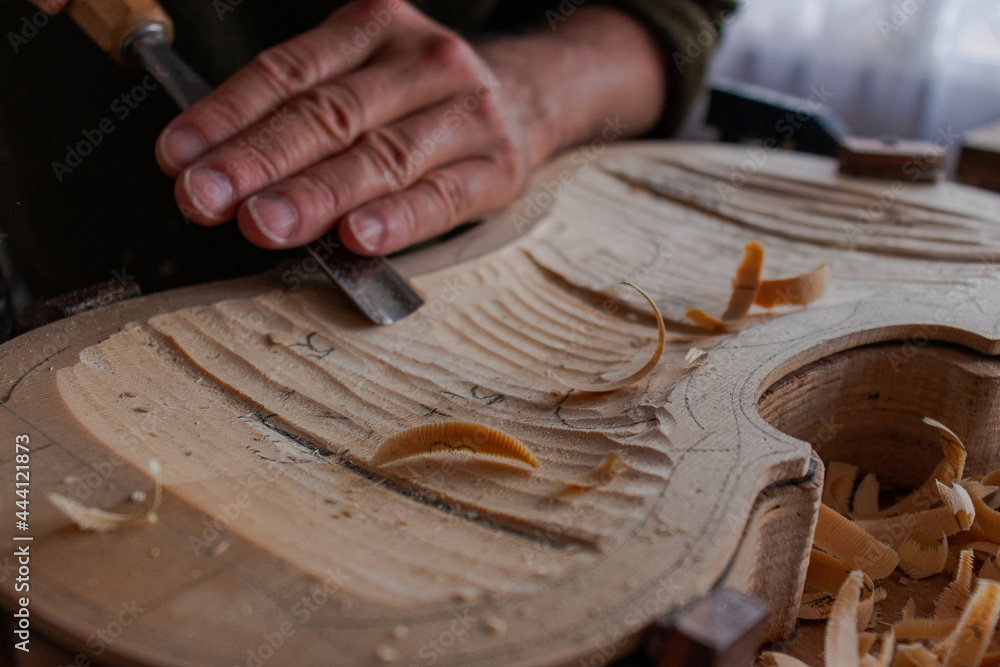 Luthier's hands using gouge to work the wood and make a violin Stock ...