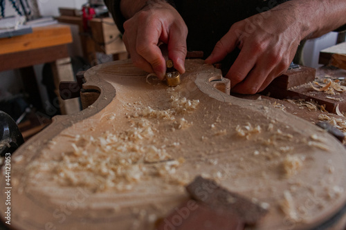 Luthier is using a little tool to give shape the violin body   © Mateo