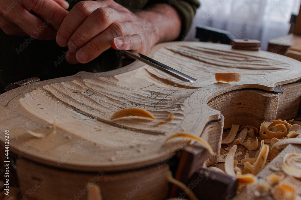 Luthier's hands using gouge to work the wood and make a violin Stock ...