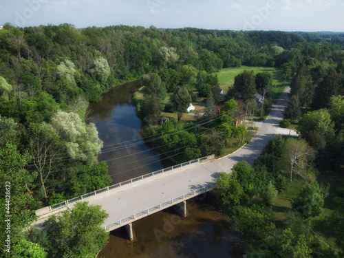 Aerial over the Mill Street bridge over the Credit River in the Cheltenham area, a community within the town of Caledon, Ontario, Canada. Shot by a drone on a hazy summer afternoon. photo