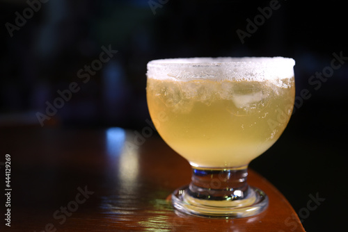 delicious and refreshing alcoholic drink with citrus fruits, margarita, cozumel on a table in a glass cup on the dark background photo