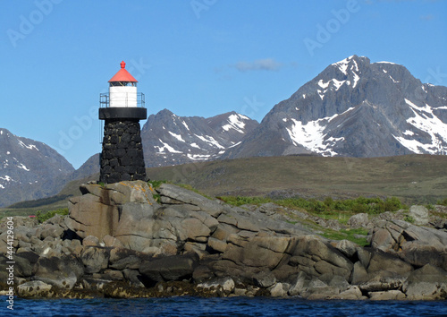  lighthouse, birds on the rocks,  and  snowy mountains  on a sunny day near leknes in the lofoten islands, nordland, norway      photo