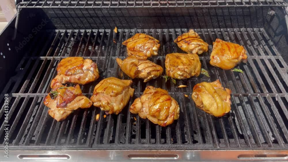 Chicken meat being grilled in barbecue cooker with smoke Chicken meat being grilled in barbecue cooker with smoke