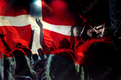 football fans supporting Denmark - crowd celebrating in stadium with raised hands against Danish flag
