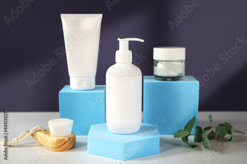 Cosmetic skincare container blank mockups in modern navy and blue styled setting with on trend shadow photography.