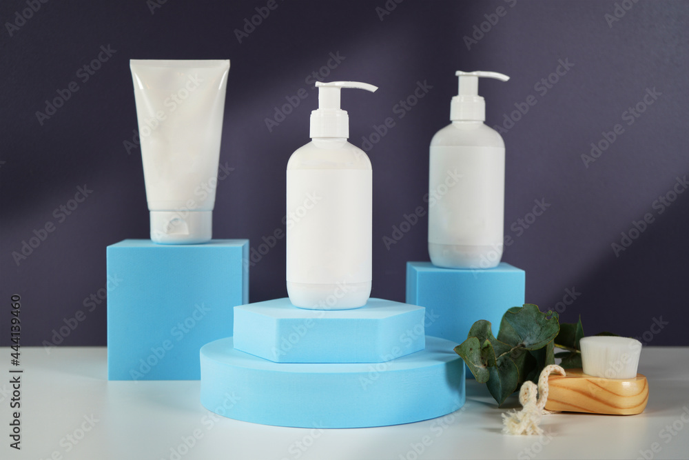 Cosmetic skincare container blank mockups in modern navy and blue styled setting with on trend shadow photography. Cosmetic skincare container blank mockups in modern navy and blue styled setting with on trend shadow photography.