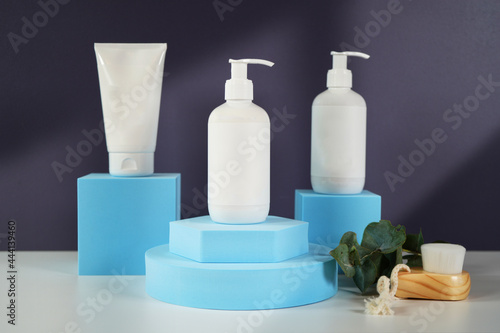 Cosmetic skincare container blank mockups in modern navy and blue styled setting with on trend shadow photography.
