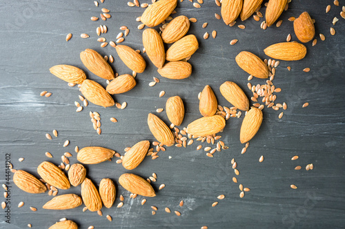 Almonds and seeds over dark textured background