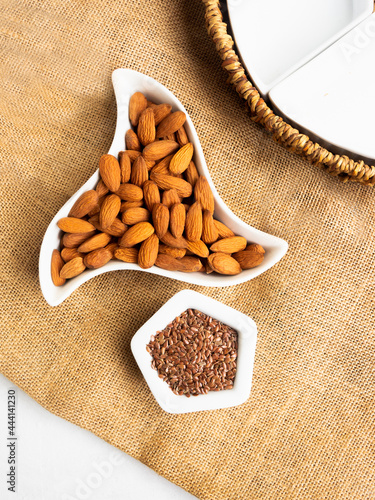 Almonds and flax seeds over linen background