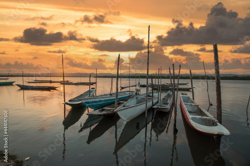 Landscape with sunset with fishing canoes on the river edge