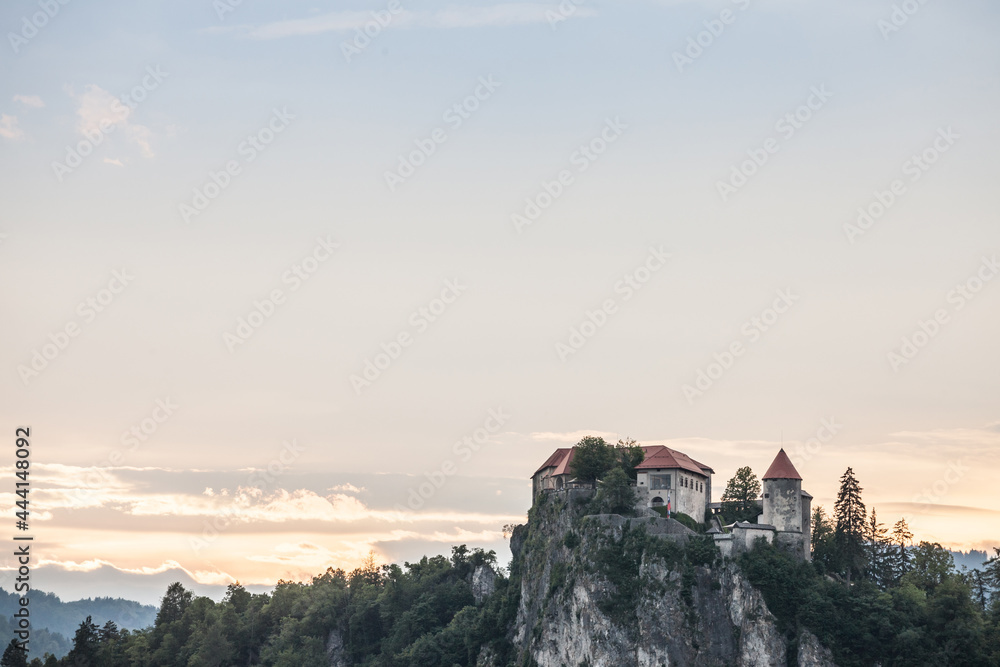 Selective blur on the Bled castle, also called Blejski Hrad, during summer, at sunset, by the mountains of Julian alps. Bled Castle is a major monument of Slovenia....
