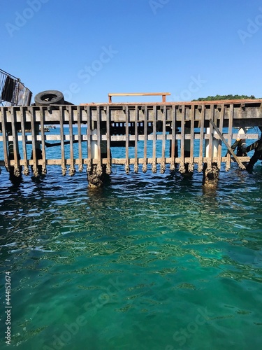 Wooden Posts In Sea Against Clear Blue Sky