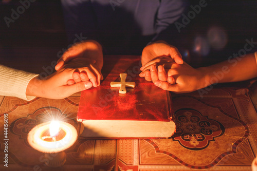 Group of people holding hands praying worship believe with lighting candle at night time.Spirituality and religion, Religious concepts