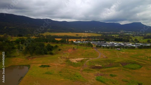 Village Houses Surrounded By Colorful Fields Near Lake Illawara In Wollongong, Australia. aerial photo