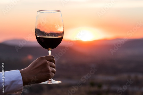 Glass of wine under sunset on the mountain