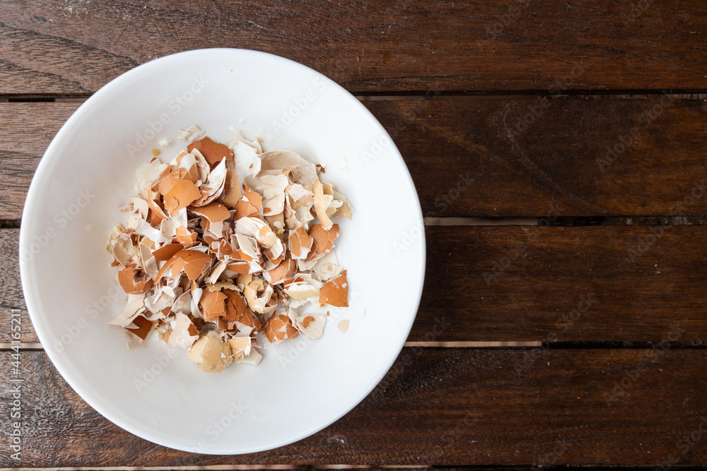 Overhead view of crushed egg shell in bowl. Egg shells are organic fertilizers for gardening rich with calcium and potassium Overhead view of crushed egg shell in bowl. Egg shells are organic fertilizers for gardening rich with calcium and potassium