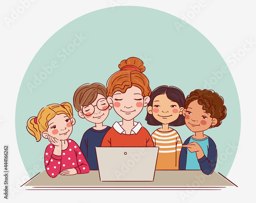 Group of school kids with teacher looking at laptop in the classroom