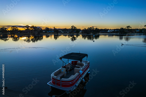 Fototapeta Naklejka Na Ścianę i Meble -  Ohmas Bay Sunset with Red Pontoon Boat