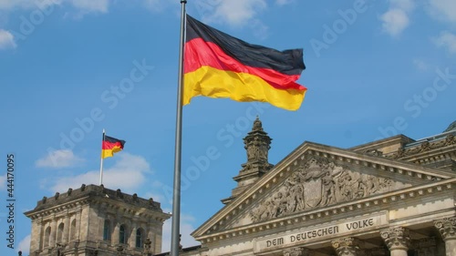 Reichstag Bundestag Berlin Deutschland Germany with german flag UHD and clouds on blue sky photo