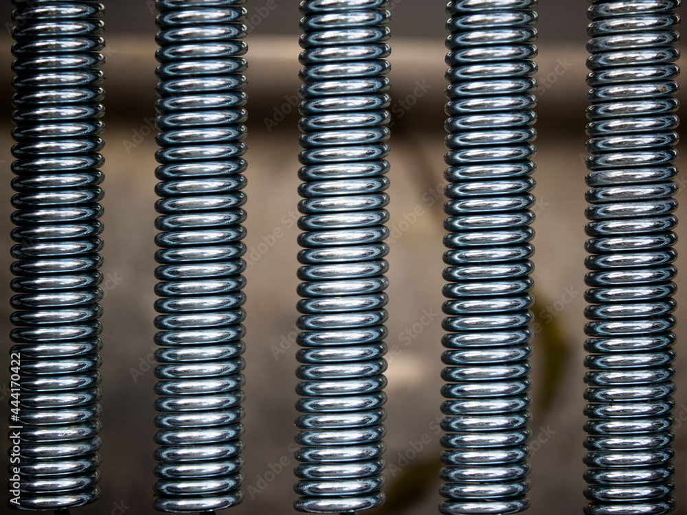 Five metal coil spring vertical close up with blurred background. Five metal coil spring vertical close up with blurred background.