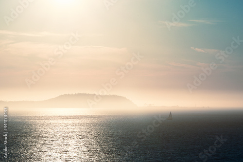 Sailboat in distance in the misty islands at dusk © Andy