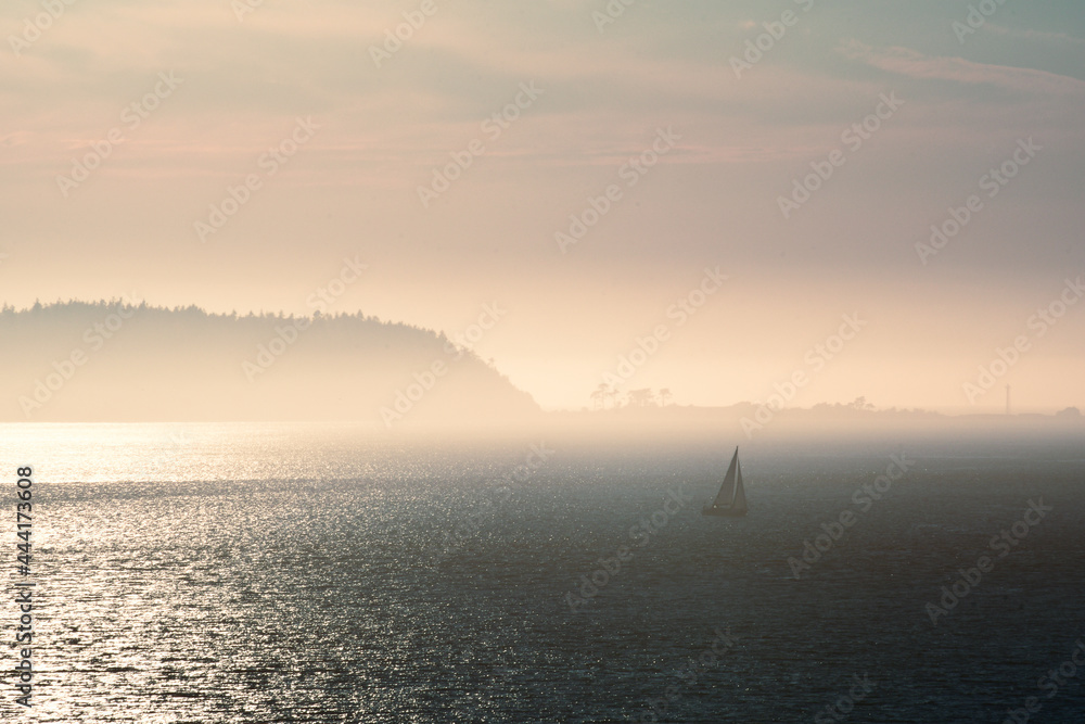 Fototapeta premium Sailboat in the misty islands at dusk