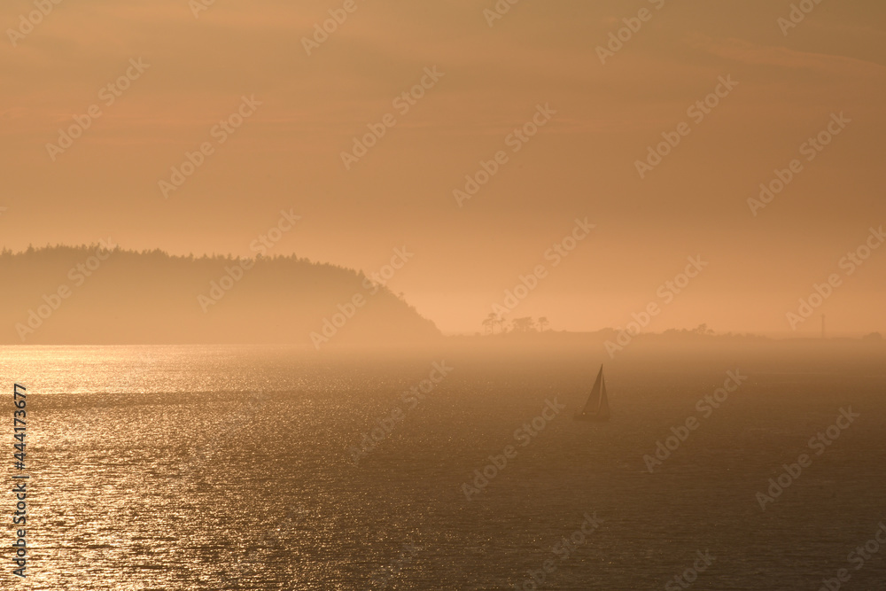 Sailboat in the misty islands at dusk
