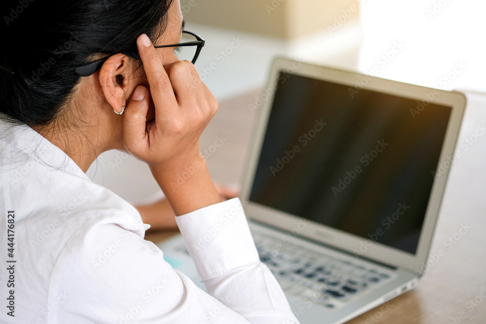 woman sitting down, his face unsettled. At the computer desk she has headaches and stress. Cause of hard work and insufficient rest. woman sitting down, his face unsettled. At the computer desk she has headaches and stress. Cause of hard work and insufficient rest.